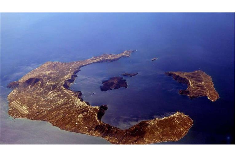 Santorini, die griechische Vulkaninsel in der Ägäis, aus der Vogelperspektive: links die Hauptinsel Thira, Nea Kameni in der Mitte der Caldera und rechts Thirasia, die den nordwestlichen Rand des Beckens bildet.