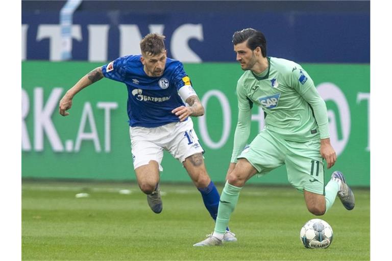 Schalkes Guido Burgstaller und Hoffenheims Florian Grillitsch (l-r.) im Zweikampf um den Ball. Foto: David Inderlied/dpa