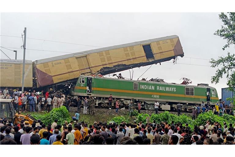 Schaulustige beobachten die Arbeit von Rettungskräften, nachdem ein Güterzug in der Nähe des Bahnhofs von New Jalpaiguri im indischen Bundesstaat Westbengalen einen Personenzug  gerammt hat.