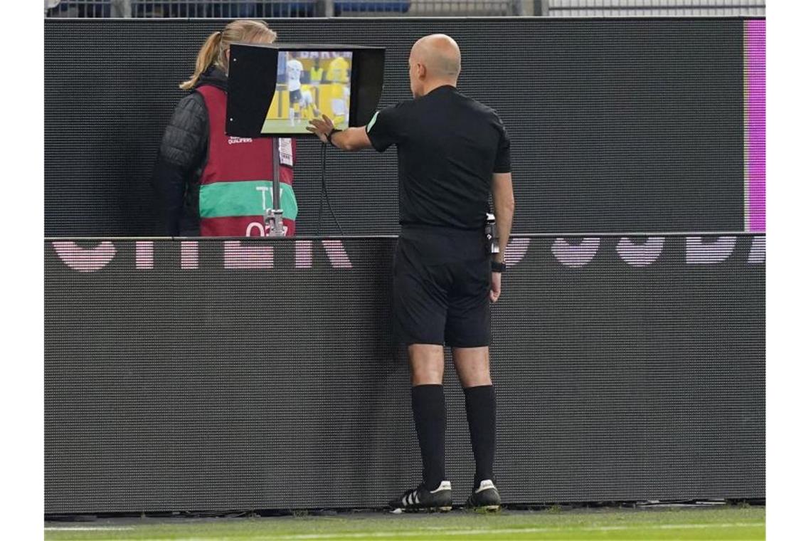 Später Sieg: Flicks Nationalteam ringt Rumänien nieder Schiedsrichter Cüneyt Cakir schaute sich die Szene zum vermeintlichen Strafstoß für Deutschland am Bildschirm an. Foto: Marcus Brandt/dpa