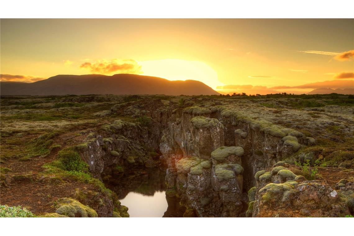 Schlucht durch die auseinanderdriftende Nordamerikanische und Eurasische Platte im Nationalpark Thingvellir im Suedisland auf Island.