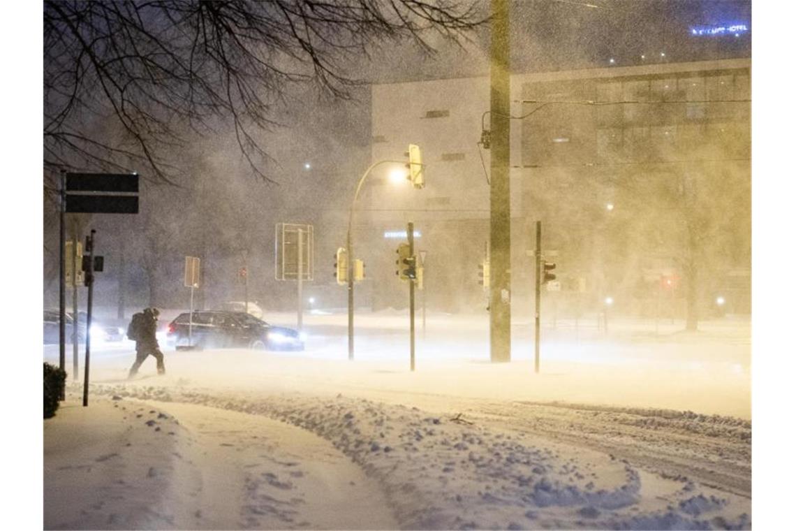 Schneesturm fegt über Deutschland - Meterhohe Verwehungen Schneegestöber und zugeschneite Straßen in Bielefeld. Dieser Mann wagt sich dennoch vor die Tür. Foto: Marcel Kusch/dpa