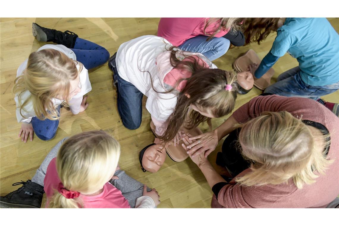 Schon in der Schule zum Lebensretter werden: Hier üben Kinder die Wiederbelebung an einer Puppe.