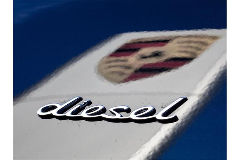 Schriftzug „Diesel“ auf einem Wagen vor der Spiegelung eines Porsche-Logos. Foto: Christoph Schmidt/Archiv