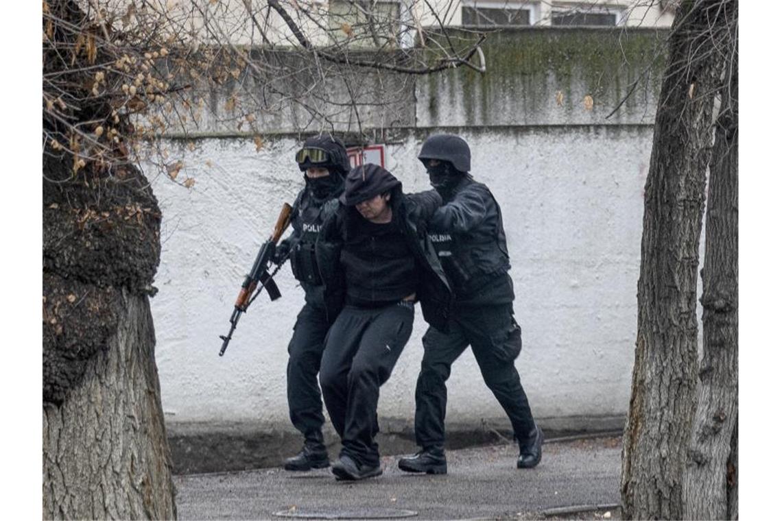 Mehr als 160 Tote bei Unruhen in Kasachstan Schwer bewaffnete Polizisten nehmen einen Mann in Almaty fest, wo es erneut schwere Unruhen gegeben hat. Foto: Vasily Krestyaninov/AP/dpa