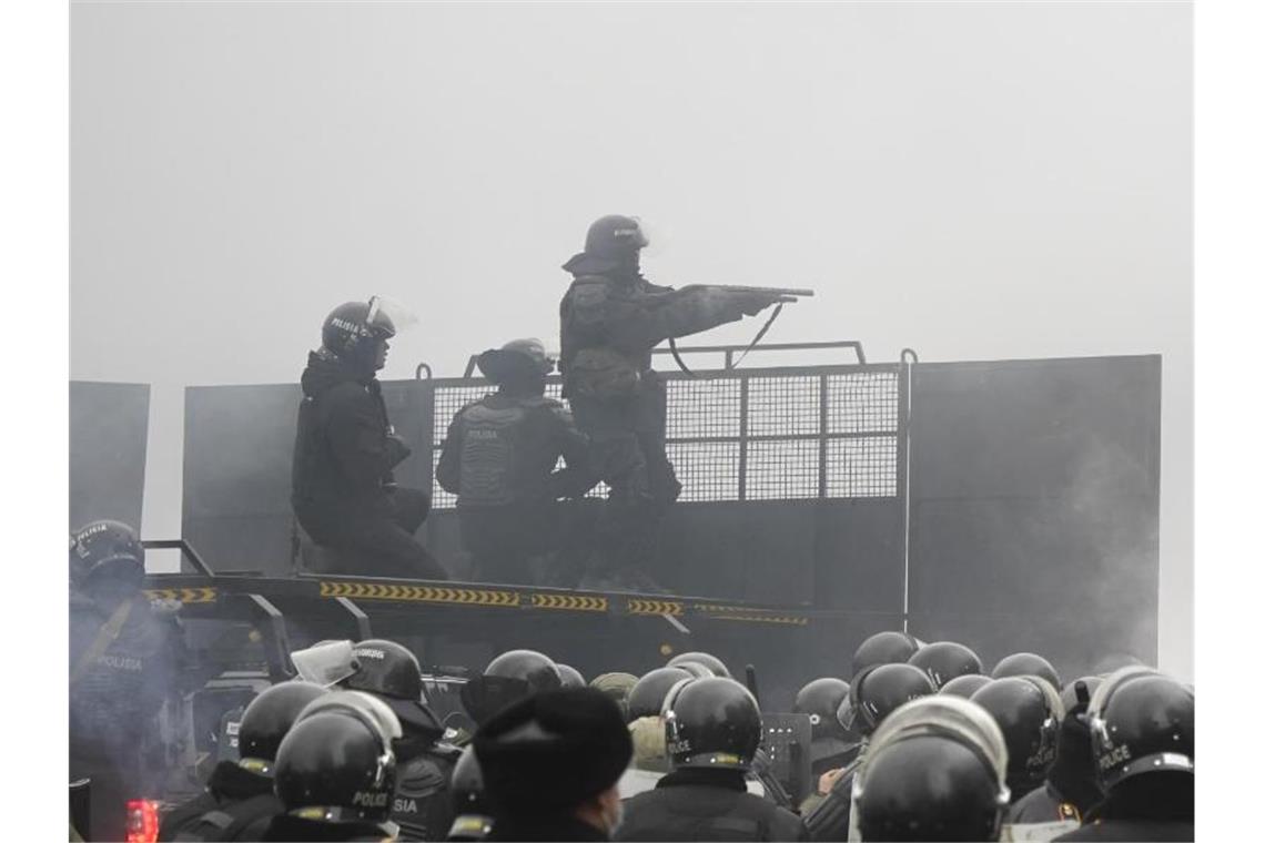 Krise in Kasachstan: Präsident erteilt Schießbefehl Schwerbewaffnete Bereitschaftspolizisten blockieren in Almaty eine Straße, um Demonstranten aufzuhalten. Foto: Vladimir Tretyakov/AP/dpa