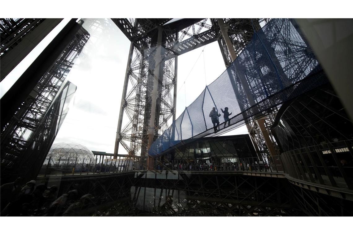 Schwindelerregend hoch: Besucher überqueren eine 40 Meter lange Brücke in rund 60 Metern Höhe, die mit Netzen ausgestattet ist und bis zum 9. März im ersten Stock des Eiffelturms aufgebaut ist.