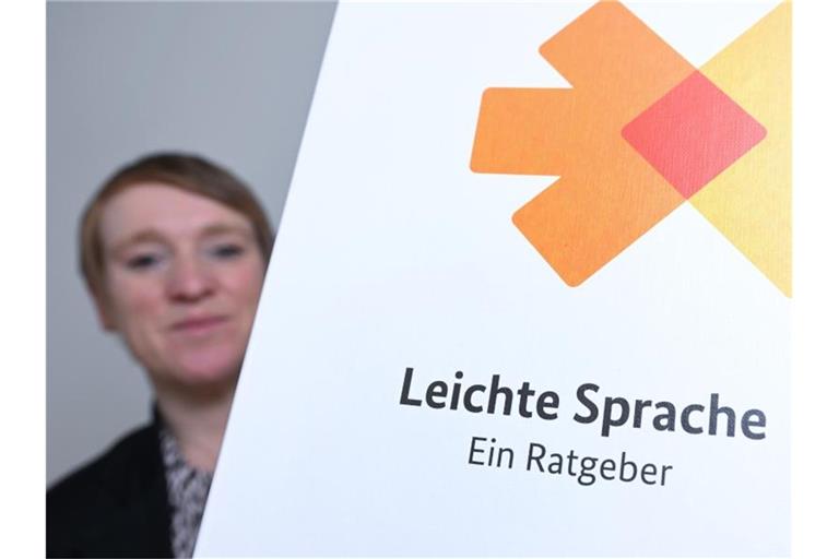 Simone Fischer, die Behindertenbeauftragte des Landes Baden-Württemberg sitzt in ihrem Büro neben einer Broschüre zum Thema leichte Sprache. Foto: Bernd Weißbrod/dpa