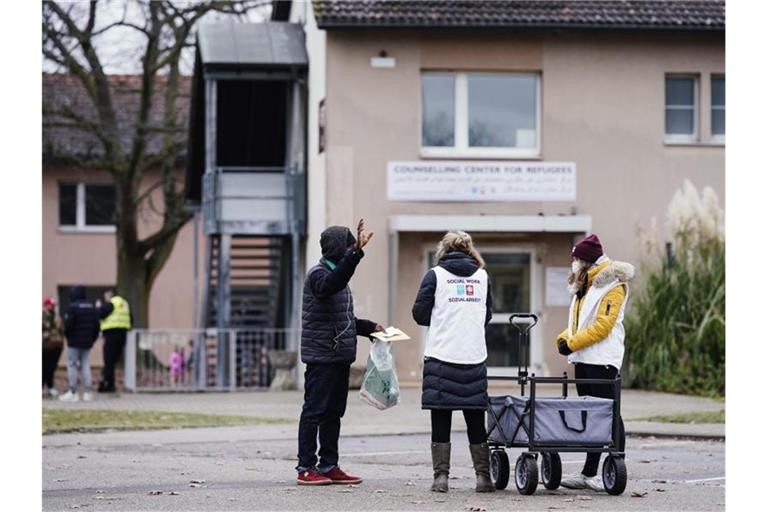 Sozialarbeiterinnen sprechen im Ankunftszentrum für Flüchtlinge mit einem Bewohner. Foto: Uwe Anspach/dpa/Archivbild