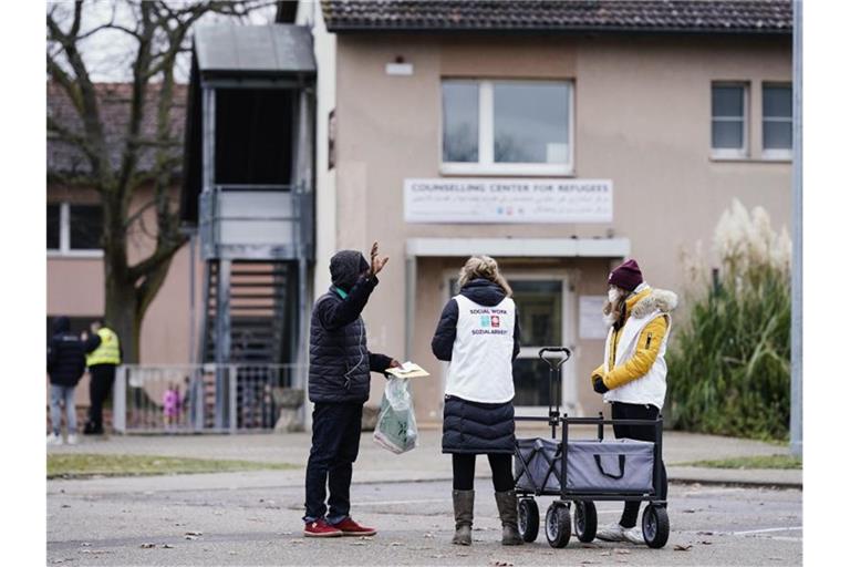 Sozialarbeiterinnen sprechen im Ankunftszentrum für Flüchtlinge mit einem Bewohner. Foto: Uwe Anspach/dpa/Archivbild