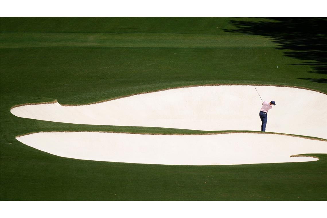 Spannung in der Ferne: Der Golfspieler Rory McIlroy aus Nordirland schlägt am achten Loch. Seit 1934 findet das Golfturnier US Masters auf demselben Golfplatz in Georgia, USA statt.