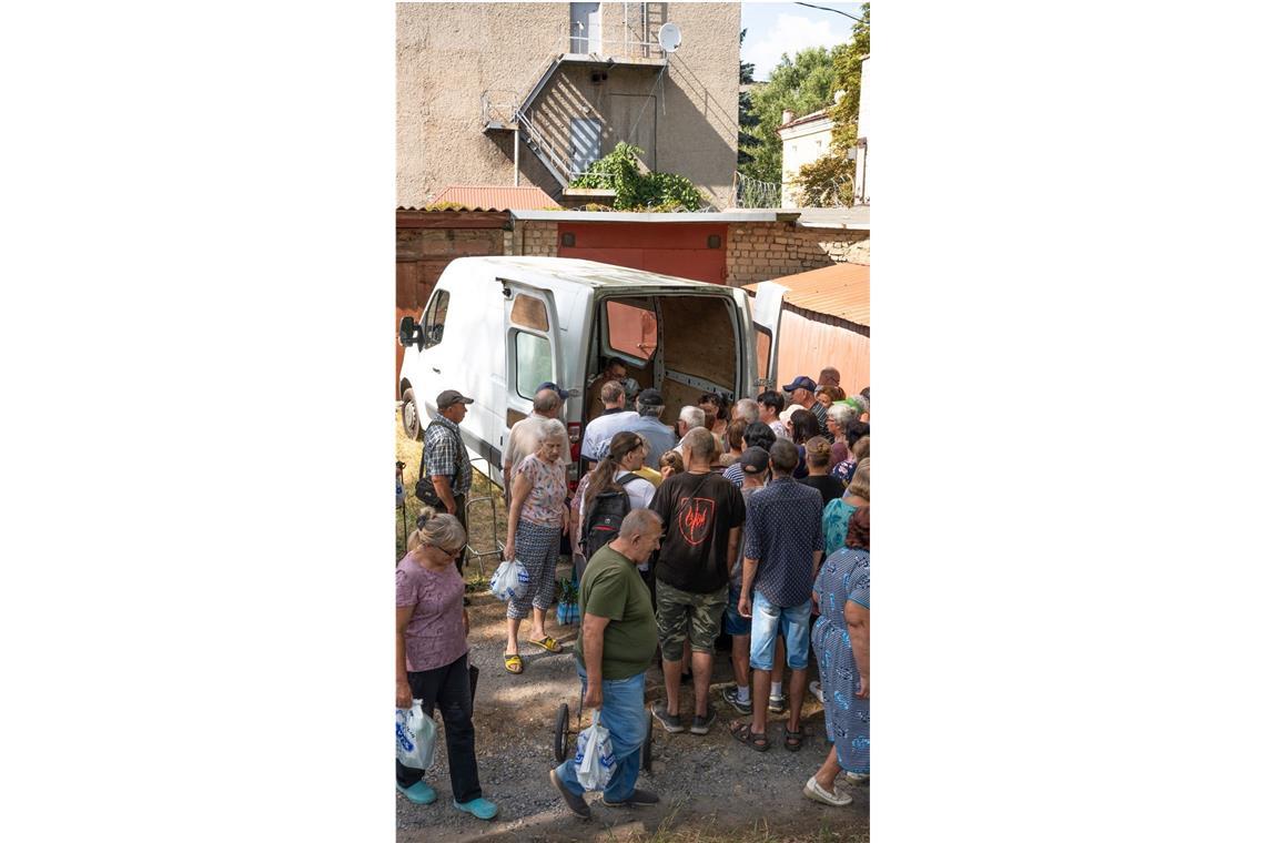 Spendenausgabe in Isjum. Über hundert Menschen warten auf ein Paket mit Seife, Waschmittel, Toilettenpapier und Zahnpasta.