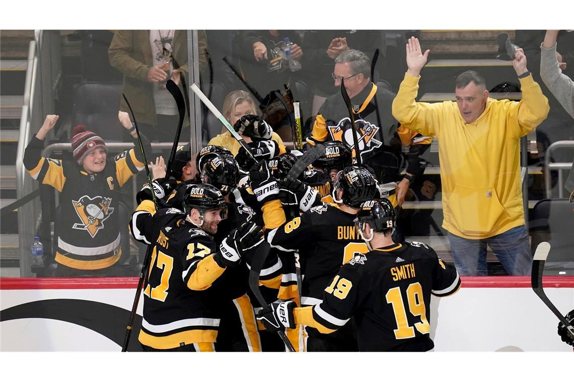 Spieler der Pittsburgh Penguins feiern nach einem Tor ihres Mannschaftskollegen Erik Karlsson in der Verlängerung. Traurige Verlierer in dem NHL-Playoff-Rennen: Moritz Seider und seine Detroit Red Wings.