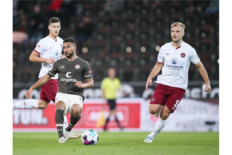 St. Paulis Daniel-Kofi Kyereh (l) und Nürnberg-Torschütze Johannes Geis teilten sich mit ihren Teams die Punkte. Foto: Selim Sudheimer/dpa