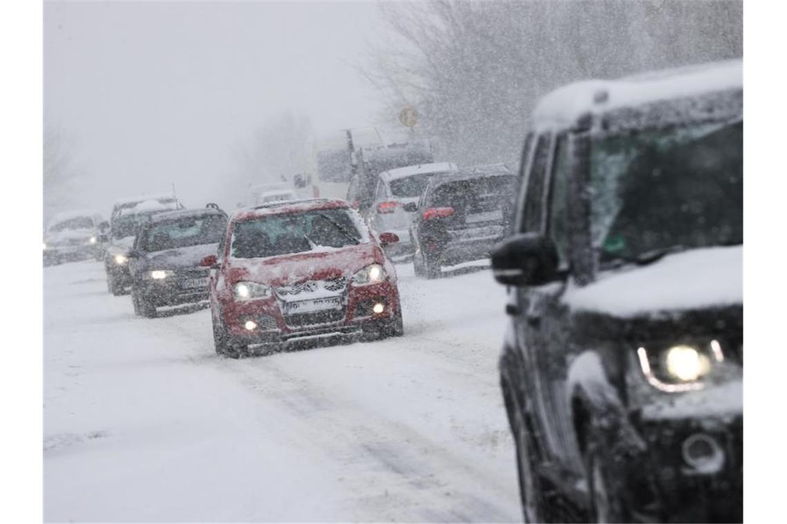 Das Extrem-Winterwetter hält an Starker Schneefall behindert den Verkehr auf einer Landstraße. Foto: Christian Charisius/dpa