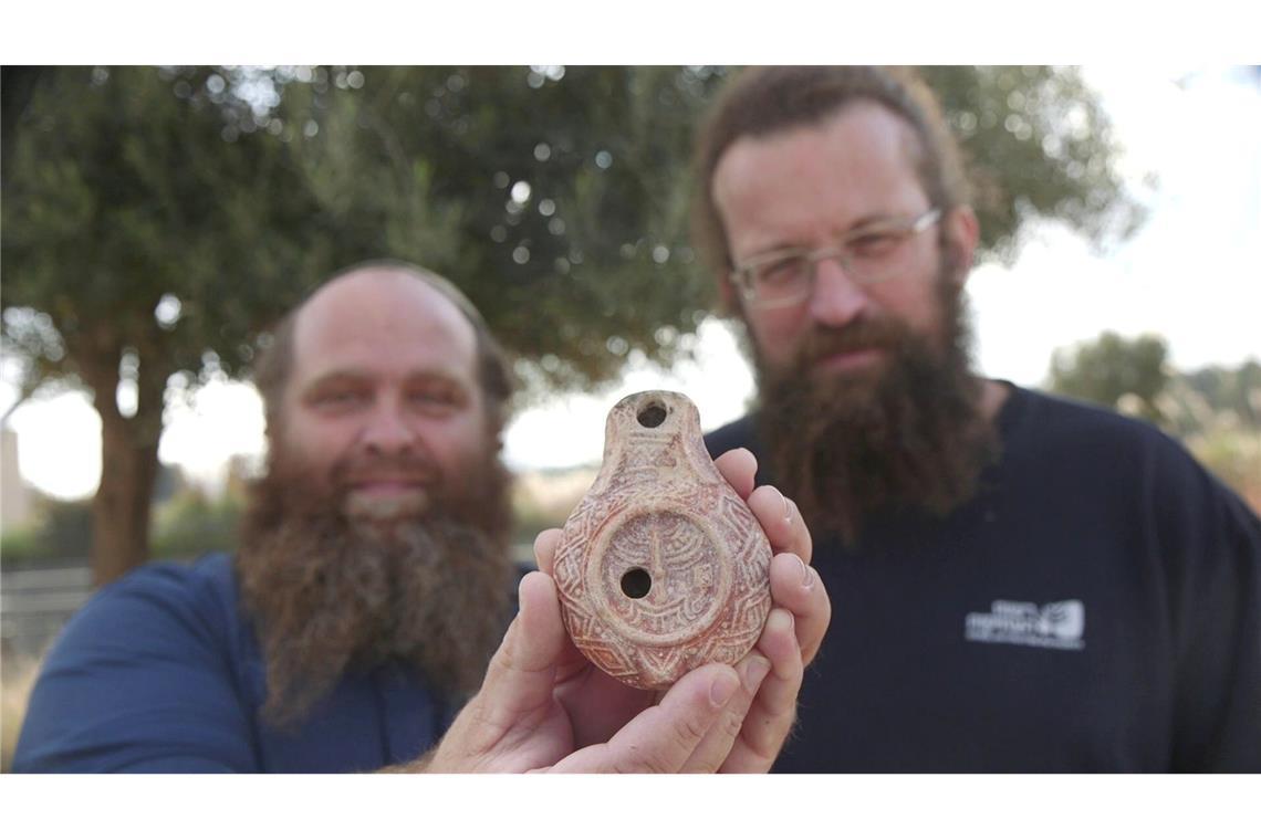 Stolz präsentieren die Archäologen ihren Fund.