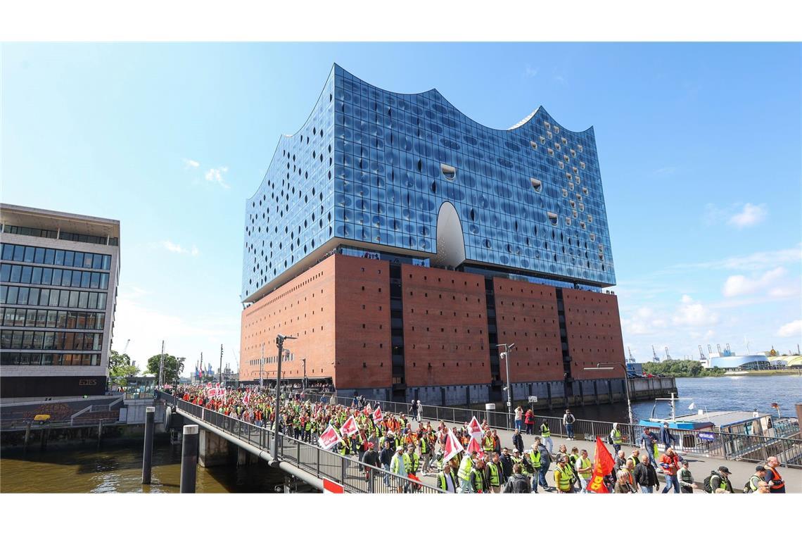 Streikende Hafenarbeiter ziehen bei einer Demonstration an der Hamburger Elbphilharmonie entlang.