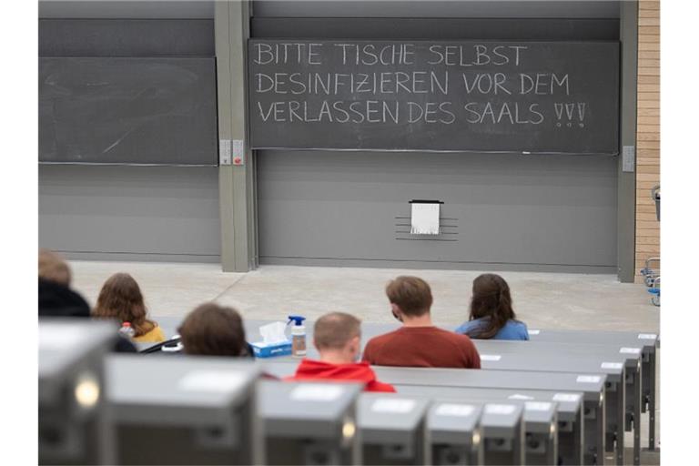 Studierende mit Mund- und Nasenmaske sitzen in einem Hörsaal. Foto: Sebastian Gollnow/dpa/Symbolbild