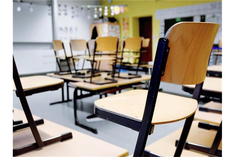 Stühle stehen in einem Klassenzimmer auf den Tischen. Foto: Caroline Seidel/dpa/Archivbild