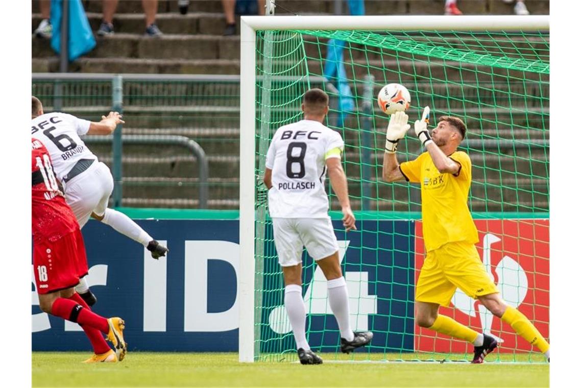 Stuttgarts Hamadi Al Ghaddioui (l) trifft zum 0:1 gegen Torwart Dmitri Stajila (r) von BFC Dynamo. Foto: Andreas Gora/dpa