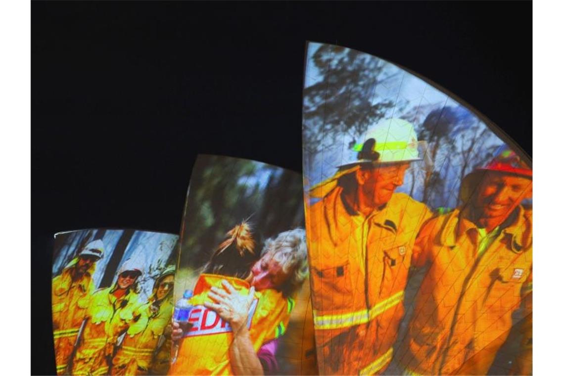 „Megafeuer“ in Australien - und die Zahl der Toten steigt Symbolischer Dank an die Einsatzkräfte in Sydney: Auf die großen Segel des Opernhauses werden als Zeichen der Solidarität Bilder von Feuerwehrleuten projiziert. Foto: Paul Braven/AAP/dpa