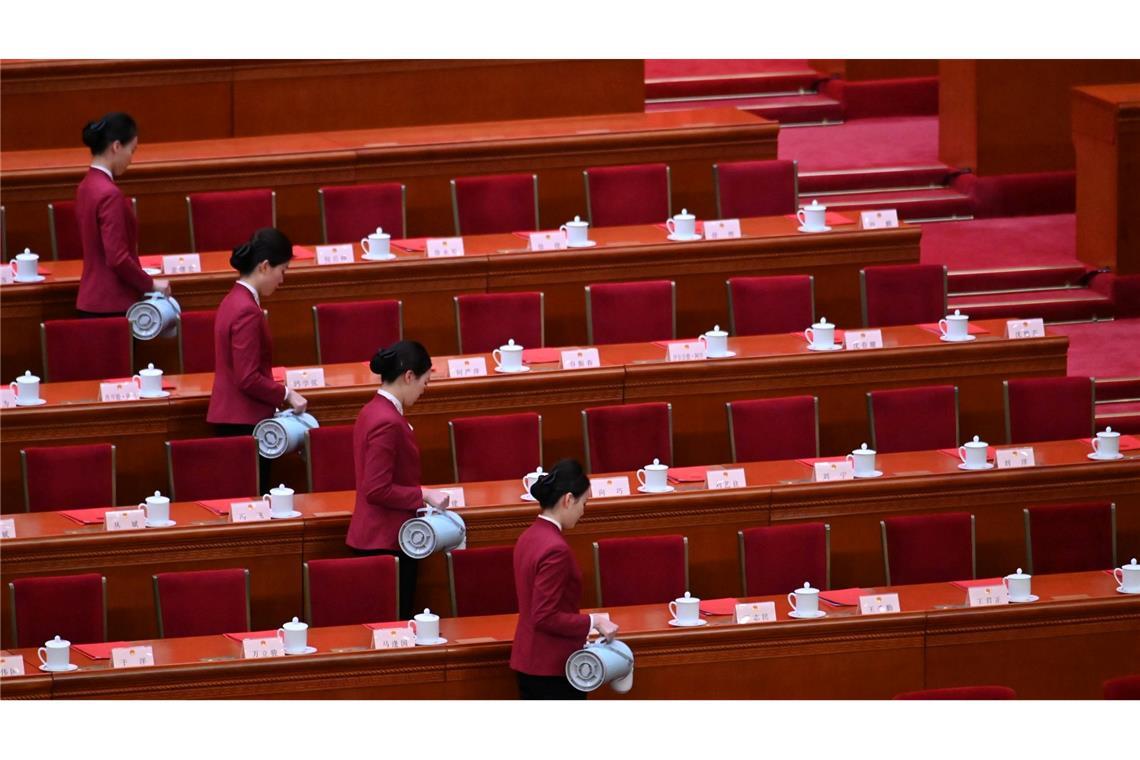 Synchron: Saalbedienstete schenken in der Großen Halle des Volkes in Peking Tee für die Delegierten des chinesischen Volkskongresses ein.