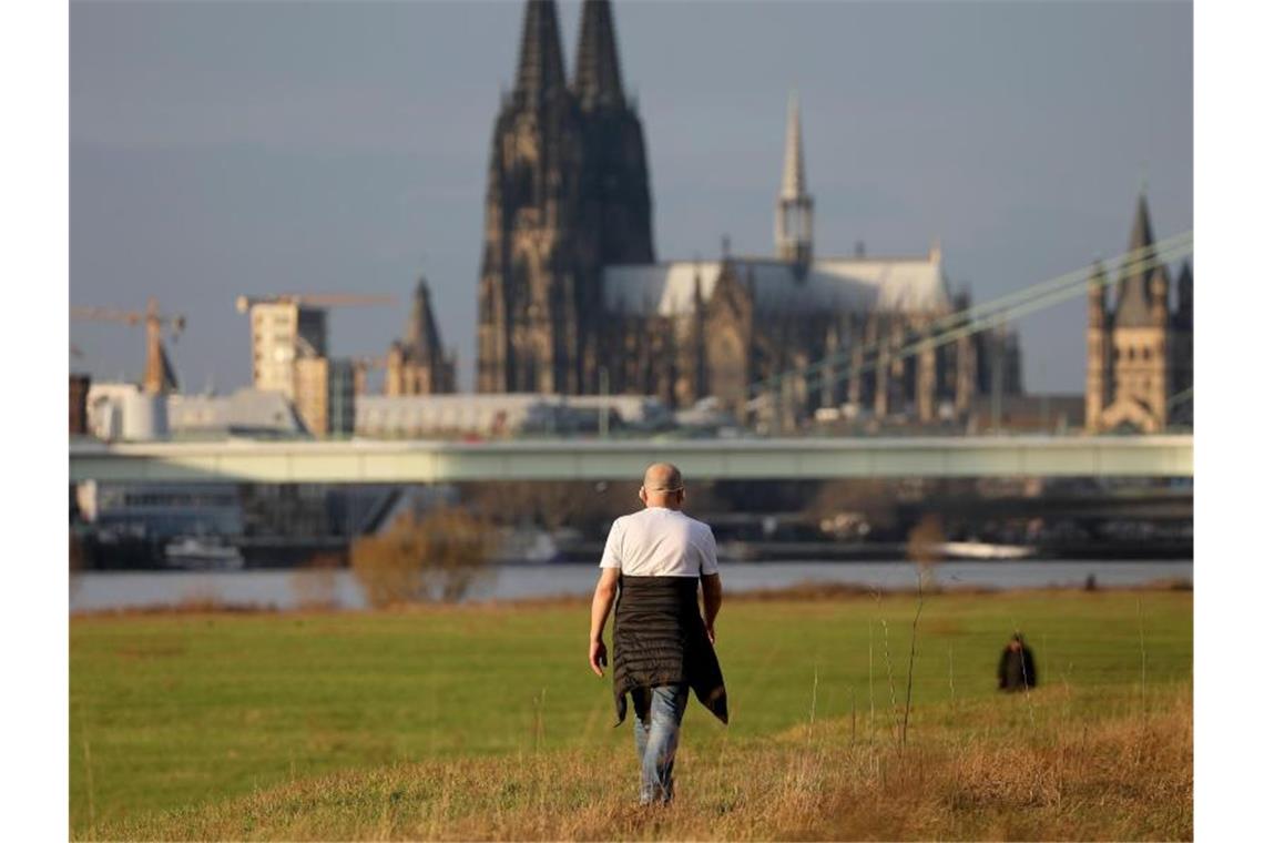 Weiße Weihnacht erscheint zunehmend unwahrscheinlich T-Shirt im Dezember: Ein Mann geht bei milden Temperaturen am Kölner Rheinufer in der Nachmittagssonne spazieren. Foto: Oliver Berg/dpa