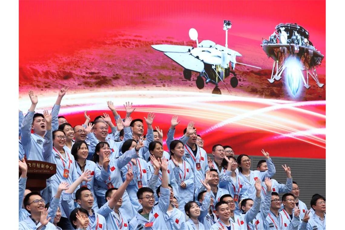 China landet mit Rover „Zhurong“ erstmals auf dem Mars Technisches Personal im Pekinger Raumfahrtkontrollzentrum feiert die erfolgreiche Landung der chinesischen Sonde Tianwen-1 auf dem Mars. Foto: XinHua/dpa