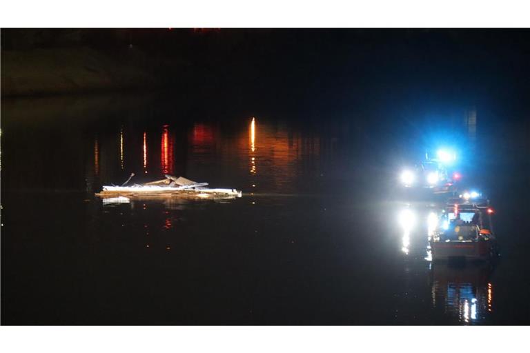 Teile eines Schiffes schwimmen im Wasser im Industriehafen während Boote im Einsatz sind. Nachdem ein Schiff in mit dem Steuerhaus an einer Brücke in Mannheim hängengeblieben und das Steuerhaus abgerissen ist, ist die Brücke für den Verkehr gesperrt.