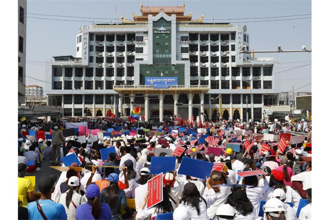 Myanmars Militär lässt die Muskeln spielen Teilnehmer eines Protestmarschs gegen den Militärputsch versammeln sich mit Plakaten vor dem Bahnhofsgebäude in Mandalay. Foto: Uncredited/AP/dpa