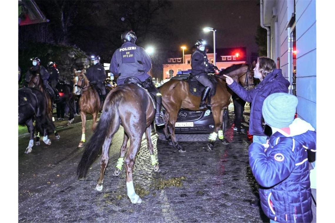 Teilnehmer eines sogenannten Spazierganges gegen die Corona-Maßnahmen gehen durch die Innenstadt. Foto: Felix Kästle/dpa/Archivbild