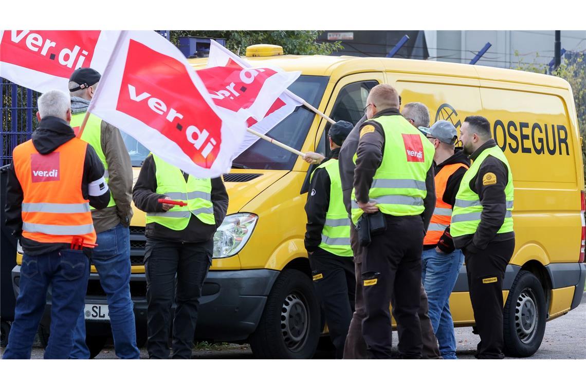 Teilnehmer eines Streiks stehen vor einer Niederlassung von Prosegur in Hamburg.