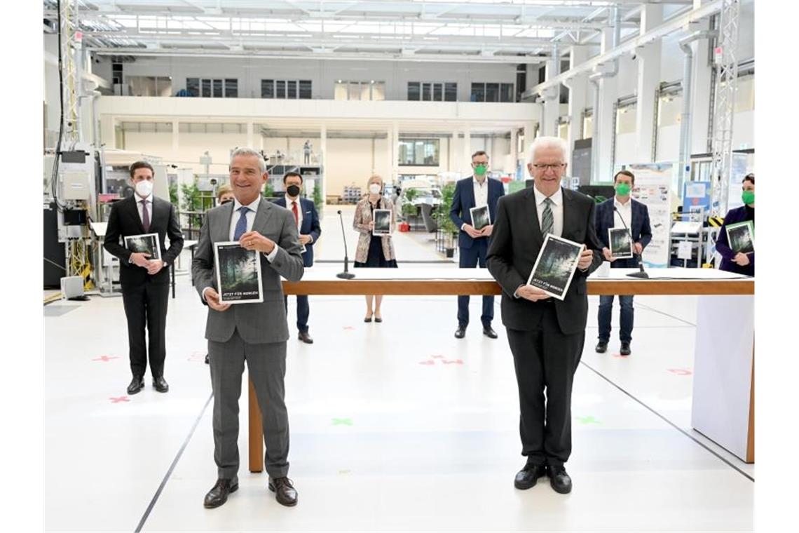 Was hält Baden-Württemberg vom Koalitionsvertrag? Thomas Strobl (CDU) und Winfried Kretschmann (Grüne) halten den Koalitionsvertrag in den Händen. Foto: Bernd Weissbrod/dpa