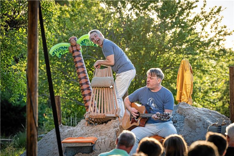 Thomas Weber (links) legt Hand an, damit das Ambiente noch besser passt, und pumpt sein Plastikpälmchen auf. James Geier unterstützt mit dem Song „Wenn jetzt Sommer wär“. Foto: Alexander Becher