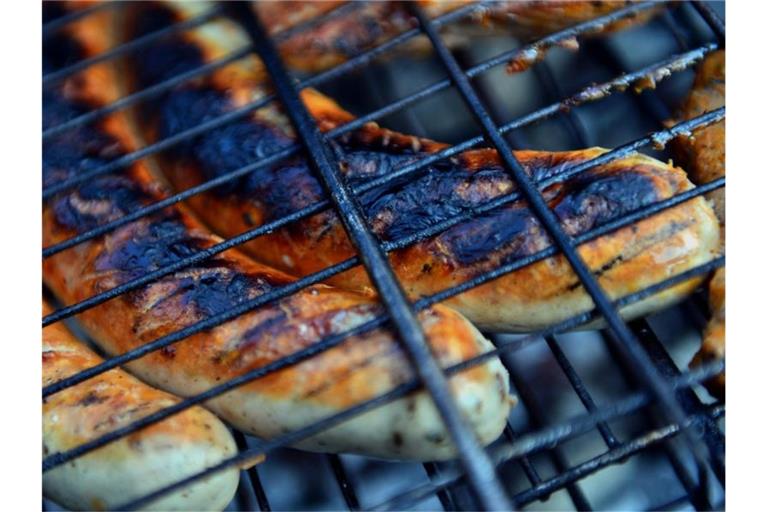 Thüringer Rostbratwürste liegen auf einem Holzkohlegrill. Foto: Hendrik Schmidt/dpa-Zentralbild/dpa/Archivbild