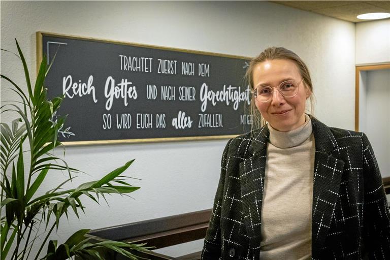 Tina Arnold vor der Hauslosung – dem Bibelvers aus der Bergpredigt Jesu, an dem sich die Missionsschule orientiert. Foto: Alexander Becher