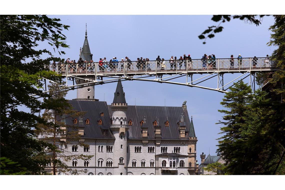 Touristen auf der Marienbrücke vor dem Schloss Neuschwanstein.