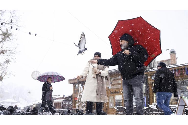 Touristen füttern Tauben bei starkem Schneefall in der Innenstadt von Sarajevo. Schneesturm hat über hunderttausend Haushalte von der Stromversorgung abgeschnitten (Archivfoto).