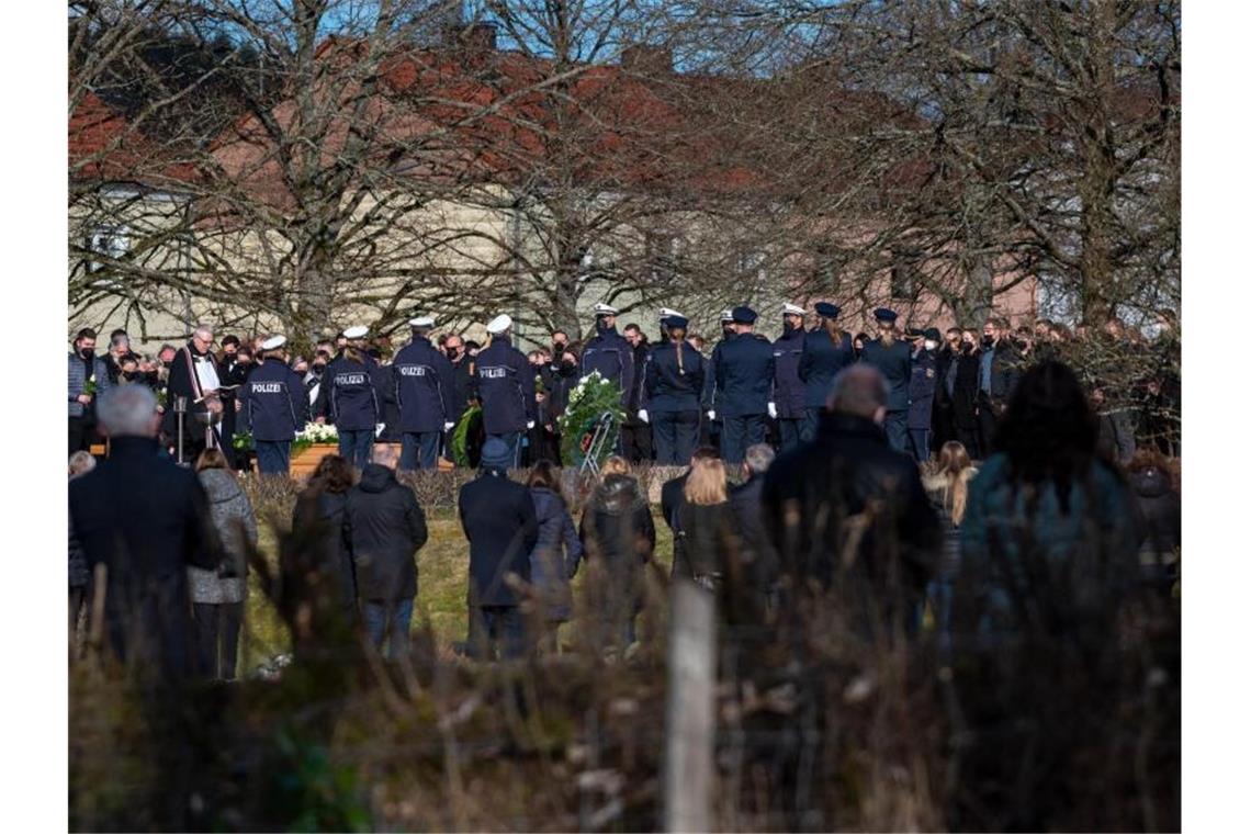 Hunderte trauern um getöteten Polizisten Trauergäste, darunter viele Polizisten, stehen am Grab bei der Beisetzung des Polizisten in Freisen. Foto: Harald Tittel/dpa