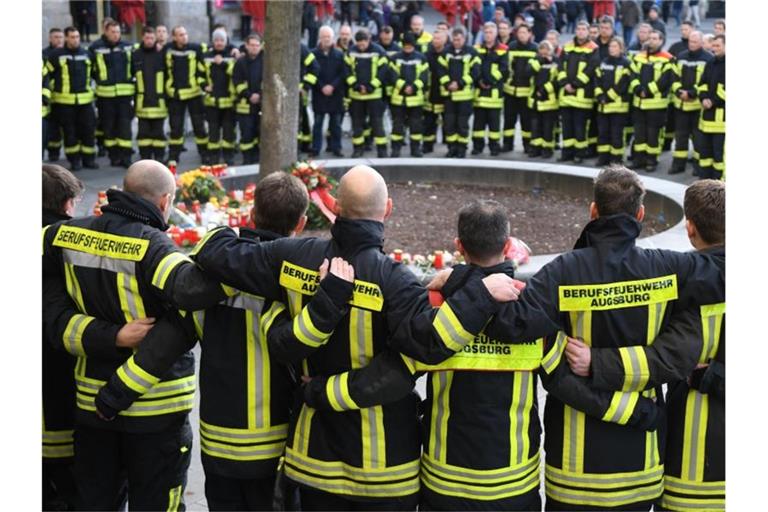 Trauernde Feuerwehrmänner im Dezember 20109 am Königsplatz in Augsburg. Foto: Stefan Puchner/dpa/Archiv