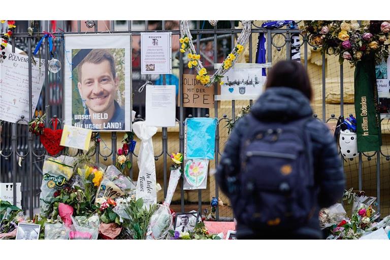 Trauernde haben ein Bild des ermordeten Polizisten Rouven Laur auf dem Mannheimer Marktplatz aufgehängt und Blumen zum Gedenken niedergelegt.