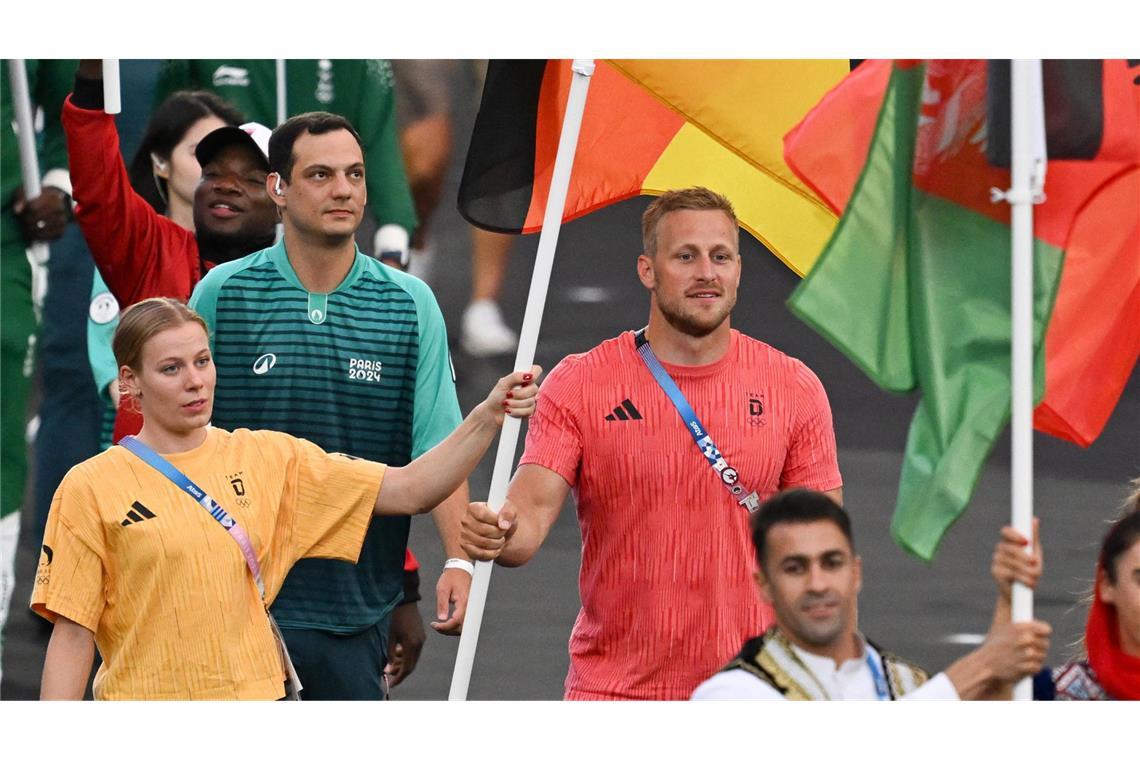 Triathletin Laura Lindemann und der Renn-Kanute Max Rendschmidt tragen bei der Schlussfeier die deutsche Fahne ins Stadion.