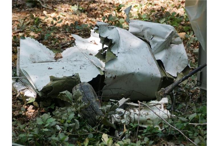 Trümmerteile von einem Kleinflugzeug vom Typ "Piper" liegen in einem Waldgebiet. Foto: Boehmler/SDMG/dpa