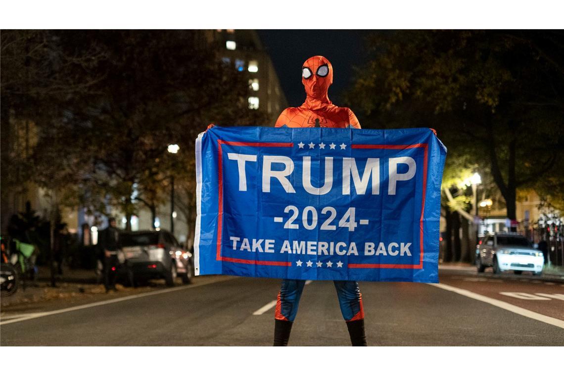 Trump-Unterstützer im Spider-Man-Kostüm mit einem Trump-Transparent am Tag der US-Präsidentschaftswahl 2024 in Washington.