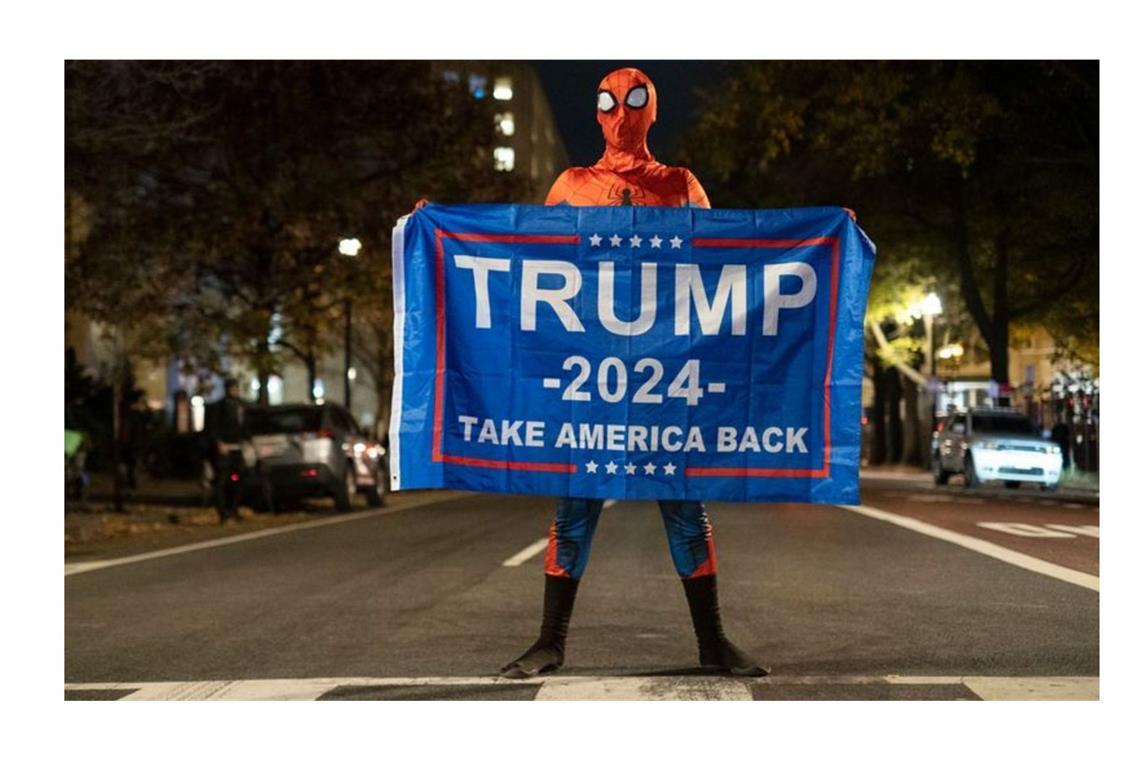 Trump-Unterstützer im Spider-Man-Kostüm mit einem Trump-Transparent am Tag der US-Präsidentschaftswahl 2024 in Washington.