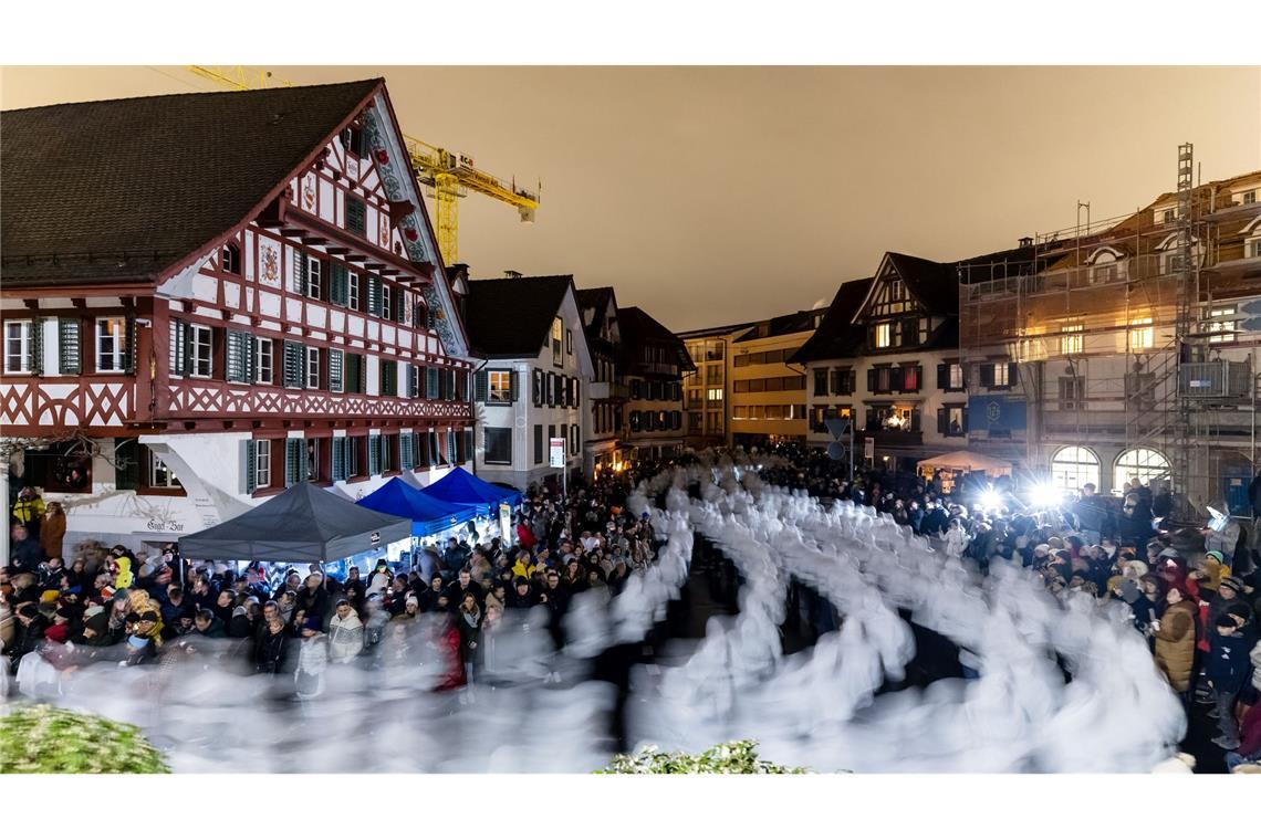 Trychler ziehen durch das dunkle Dorf Küssnacht im Kanton Schwyz während des traditionellen Klausjagens - ein Brauch der traditionell am Abend vor Nikolaus veranstaltet wird.