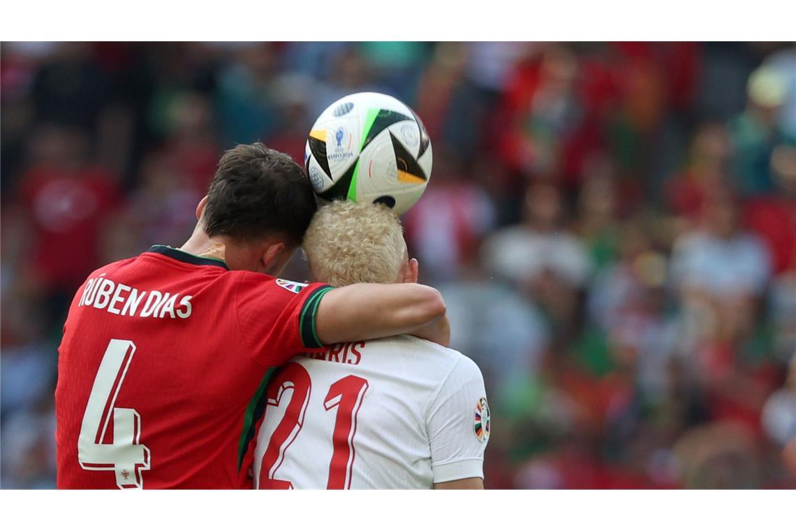 Umarmung in der Luft: Portugals Ruben Dias (l.) und der türkische Nationalspieler Baris Yilmaz im Zweikampf während der Fußball-EM-Partie in Dortmund.