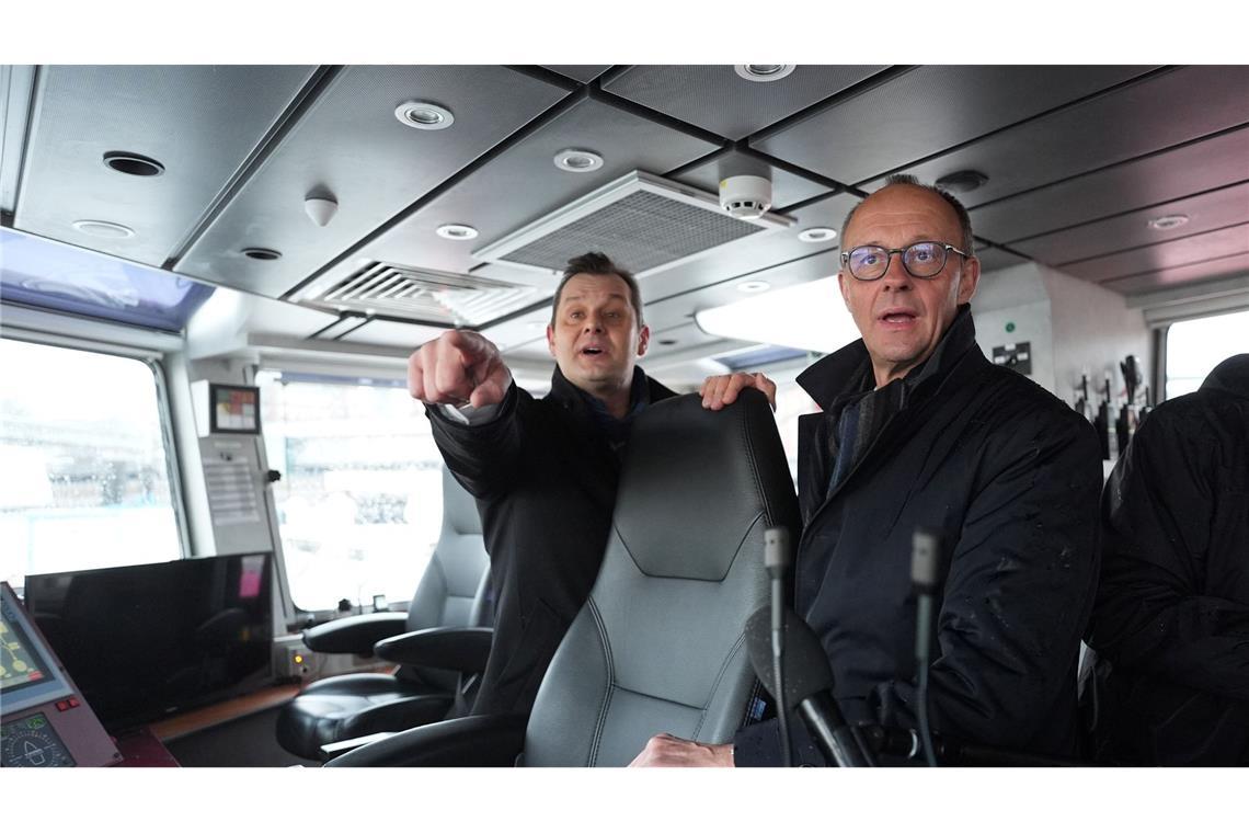 Unionskanzlerkandidat Friedrich Merz lässt sich vom Inhaber des Hamburger Unternehmens VB Group beim Besuch des Feuerlöschboots "Prag" den Hamburger Hafen zeigen.