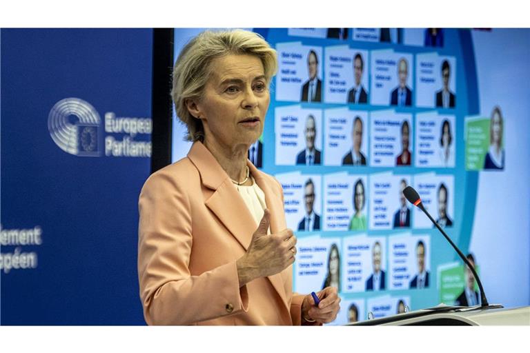 Ursula von der Leyen bei der Präsentation ihrer Kommissarinnen und Kommissare, deren Fotos hinter ihr zu sehen sind.