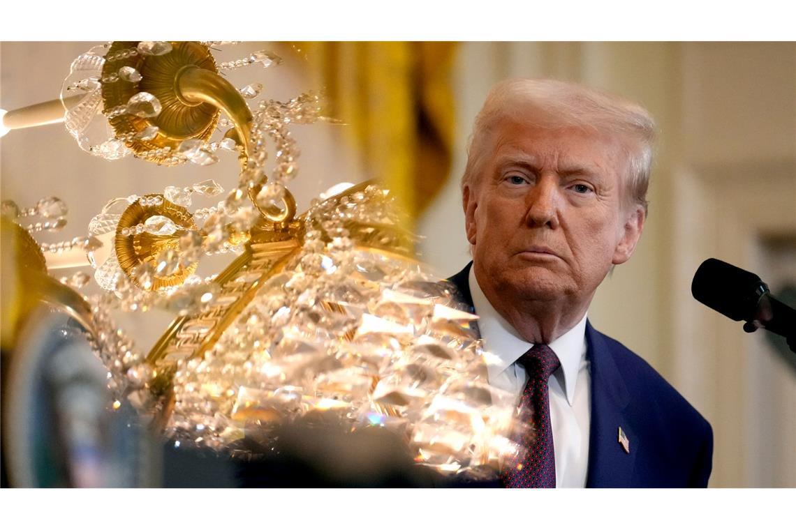 US-Präsident Donald Trump hört während einer Pressekonferenz mit dem indischen Premierminister Modi im East Room des Weißen Hauses zu, während sich ein Kronleuchter im Glas des Teleprompters spiegelt.